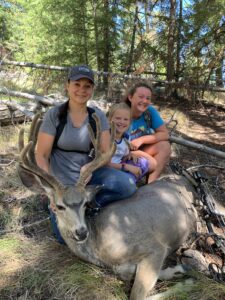 Woman and her daughters with archery mule deer buck in velvet