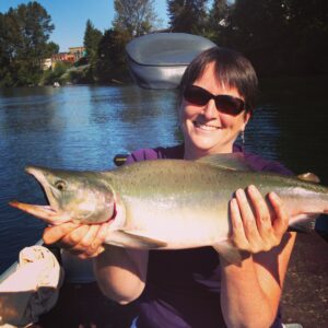 Smiling woman holding a pink salmon